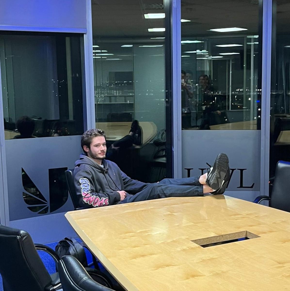 picture of man in board office with his feet up on table